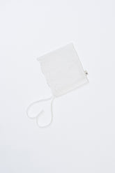 Avauma Clare Bonnet - Cotton Cream laid flat on white background, featuring floral punch lace and ribbon ties